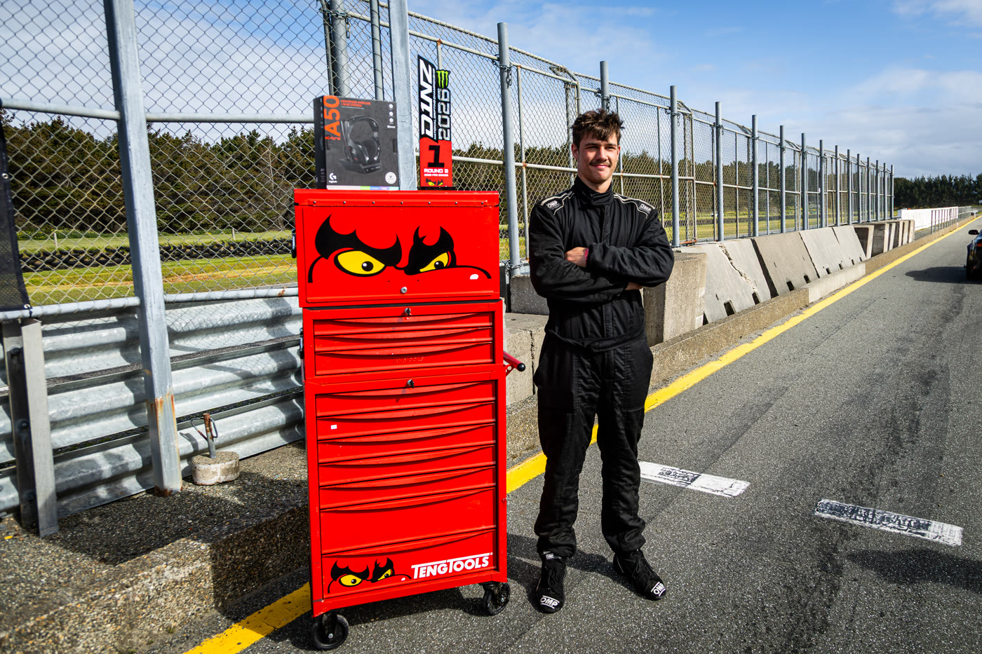 A D1NZ driver beside his TengTools prize chest in pit lane