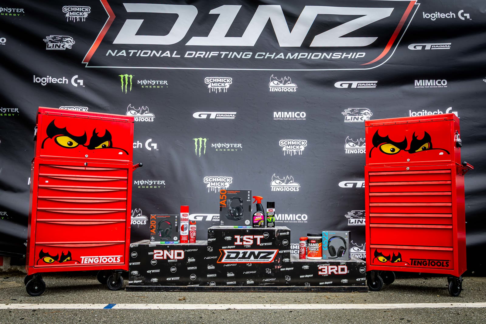 The D1NZ prize display flanked by two red TengTools chests in front of the sponsor wall