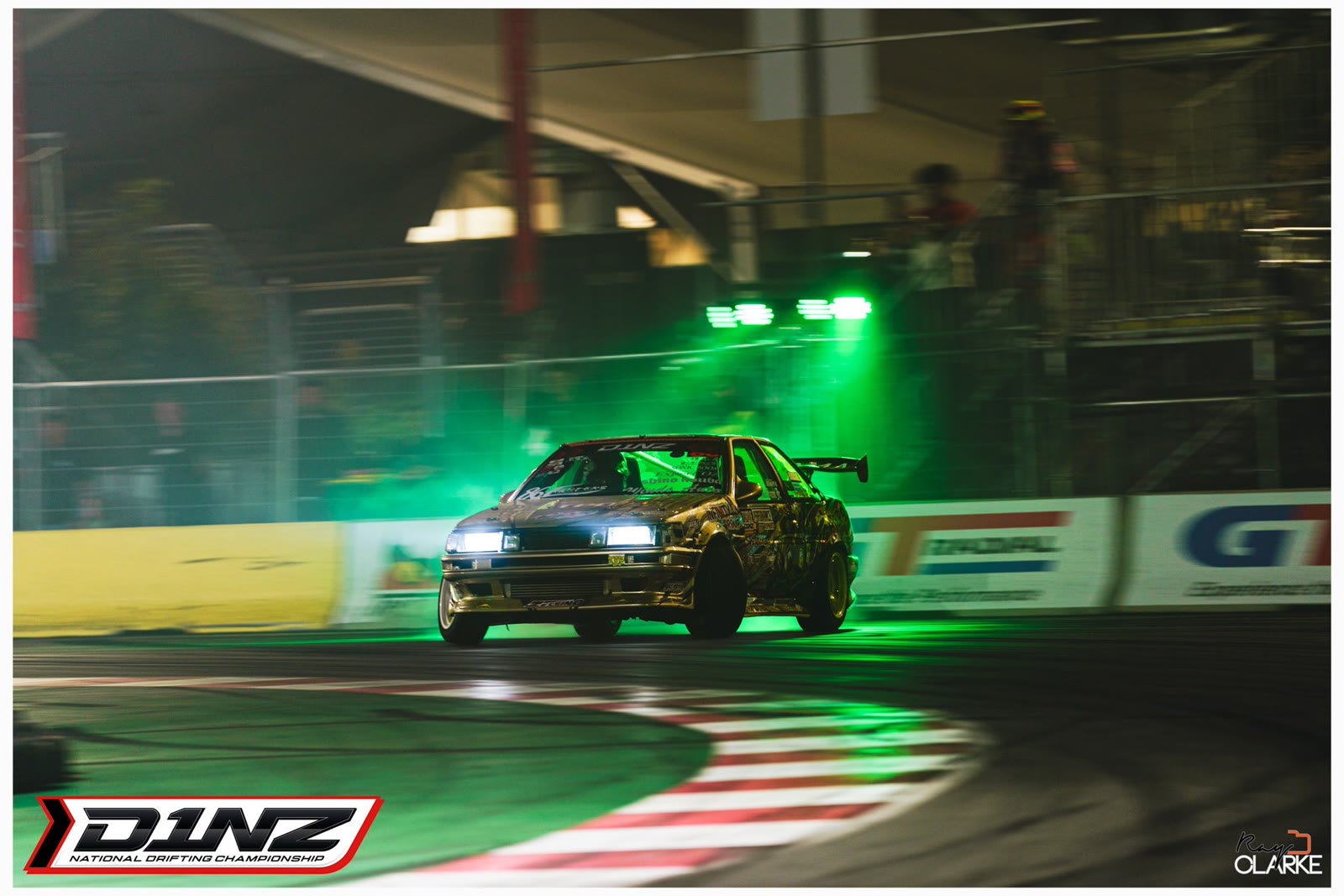 A D1NZ car lit up in Monster green smoke as it launches onto the track