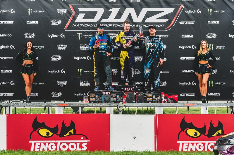 D1NZ podium with drivers, trophies and Monster branding